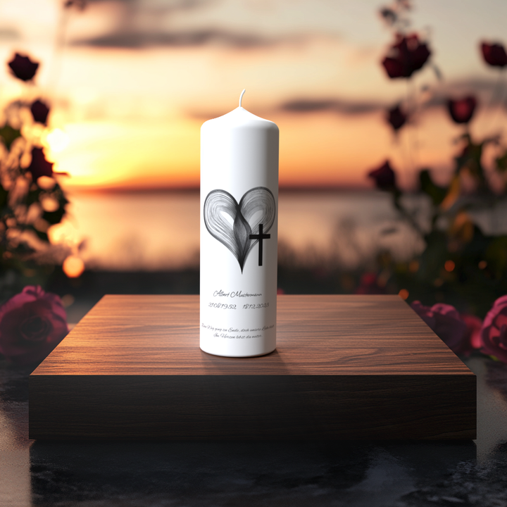 Weiße Trauerkerze mit Herzlinien und Kreuz auf Holzpodest bei Sonnenuntergang – Symbol für Liebe, Glauben und bleibende Erinnerung.