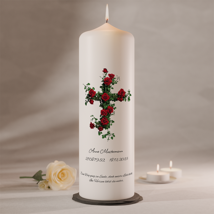 Moderne Trauerkerze mit Kreuz aus roten Rosen auf weißer Gedenkkerze als Symbol für Liebe und Erinnerung