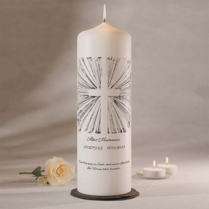 Weiße Trauerkerze mit silbernem Strahlenkreuz und individueller Beschriftung, stehend auf dunklem Kerzenteller neben weißer Rose und Teelichtern
