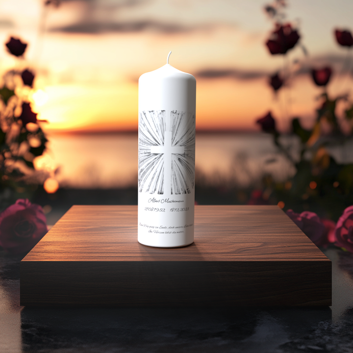 Weiße Trauerkerze mit silbernem Strahlenkreuz auf Holzpodest vor Sonnenuntergang, Symbol für Trost, Hoffnung und das ewige Licht der Erinnerung.