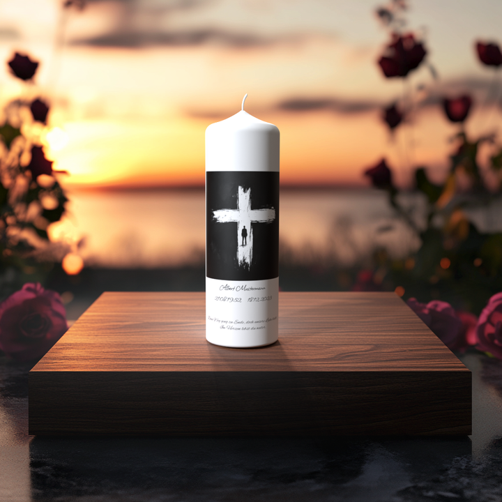 Weiße Trauerkerze mit weißem Kreuz auf schwarzem Hintergrund, auf Holzpodest vor Sonnenuntergang – Symbol für Glauben, Hoffnung und Erinnerung.