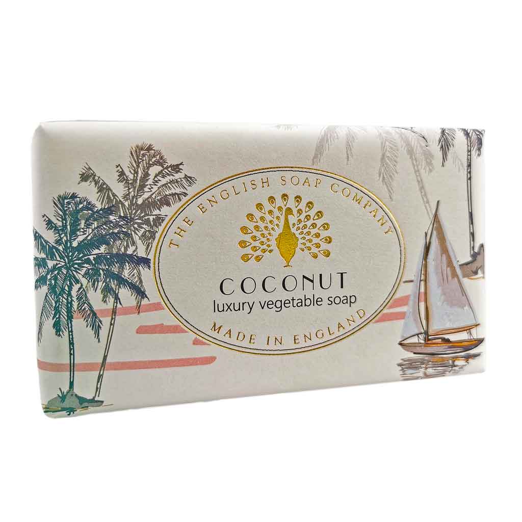 Helle Seife mit tropischem Strandmotiv, Palmen und Segelboot in Illustration, Aufschrift „Coconut – luxury vegetable soap“.