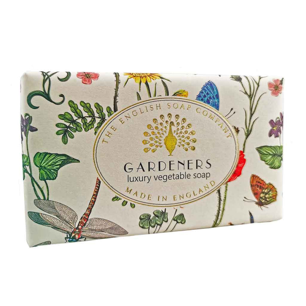 Seife mit botanischen Illustrationen, Schmetterlingen und Libellen, schräg fotografiert, Aufschrift „Exfoliating Gardeners – luxury vegetable soap“.