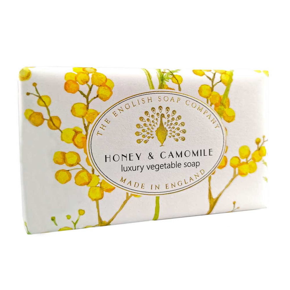 Seife mit gelbem Blütenmotiv in leichter Schrägansicht, Aufschrift „Honey & Camomile – luxury vegetable soap“.