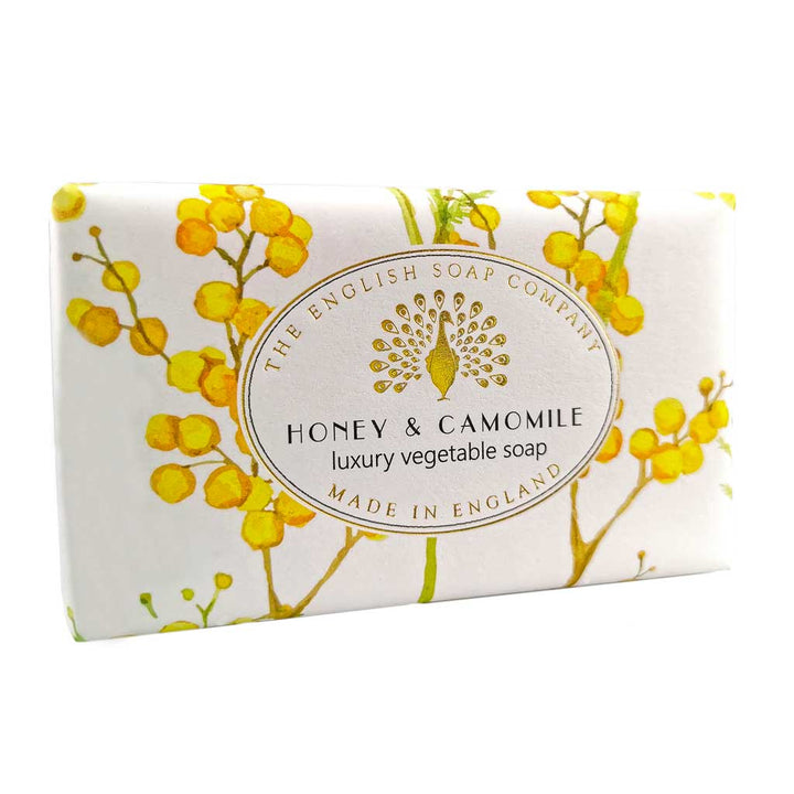 Seife mit gelbem Blütenmotiv in leichter Schrägansicht, Aufschrift „Honey & Camomile – luxury vegetable soap“.