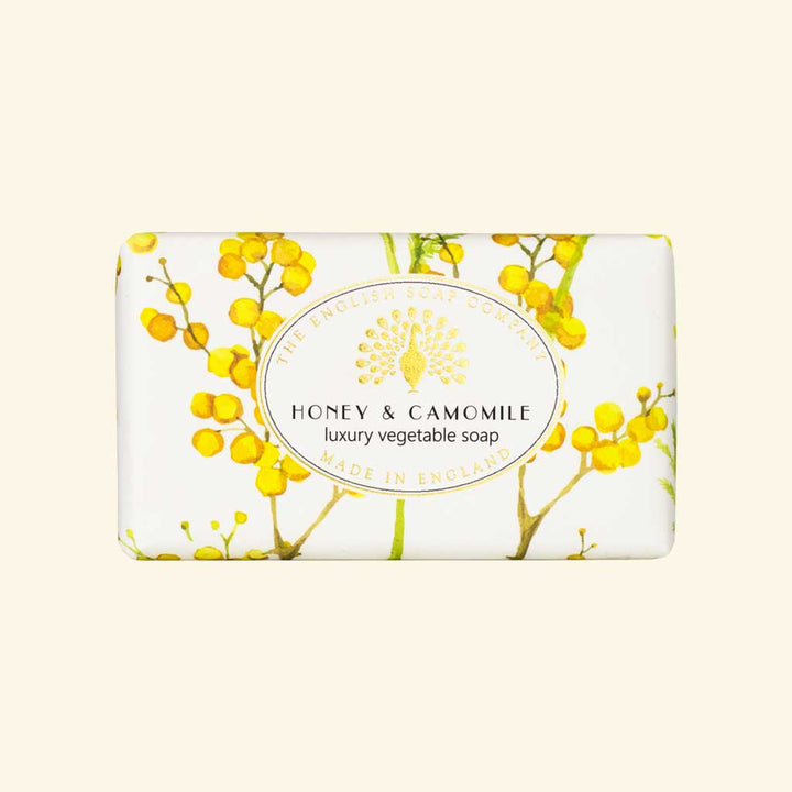 Seife mit gelbem Blütenmotiv und Aufschrift „Honey & Camomile – luxury vegetable soap“.