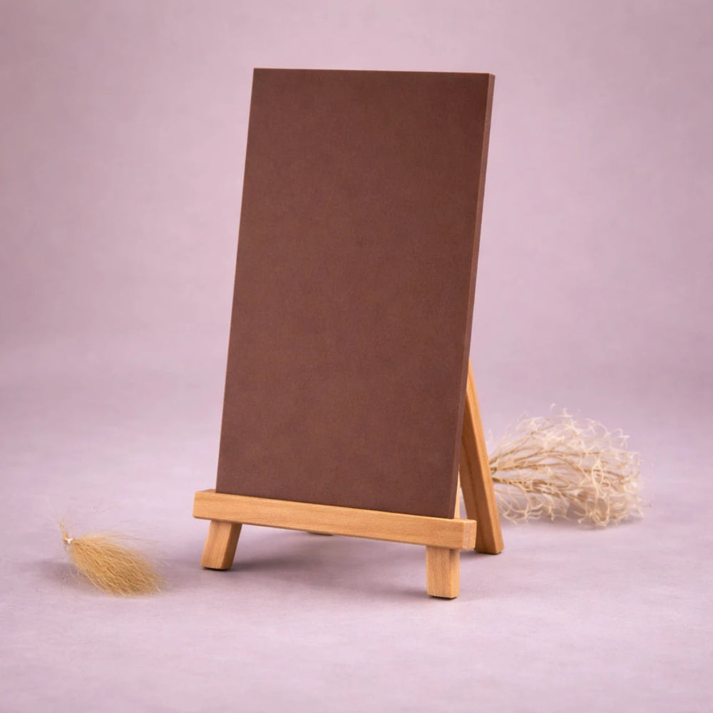 braune wachsplatte zur kerzengestaltung auf kleiner holzstaffelei vor neutralem beigem hintergrund