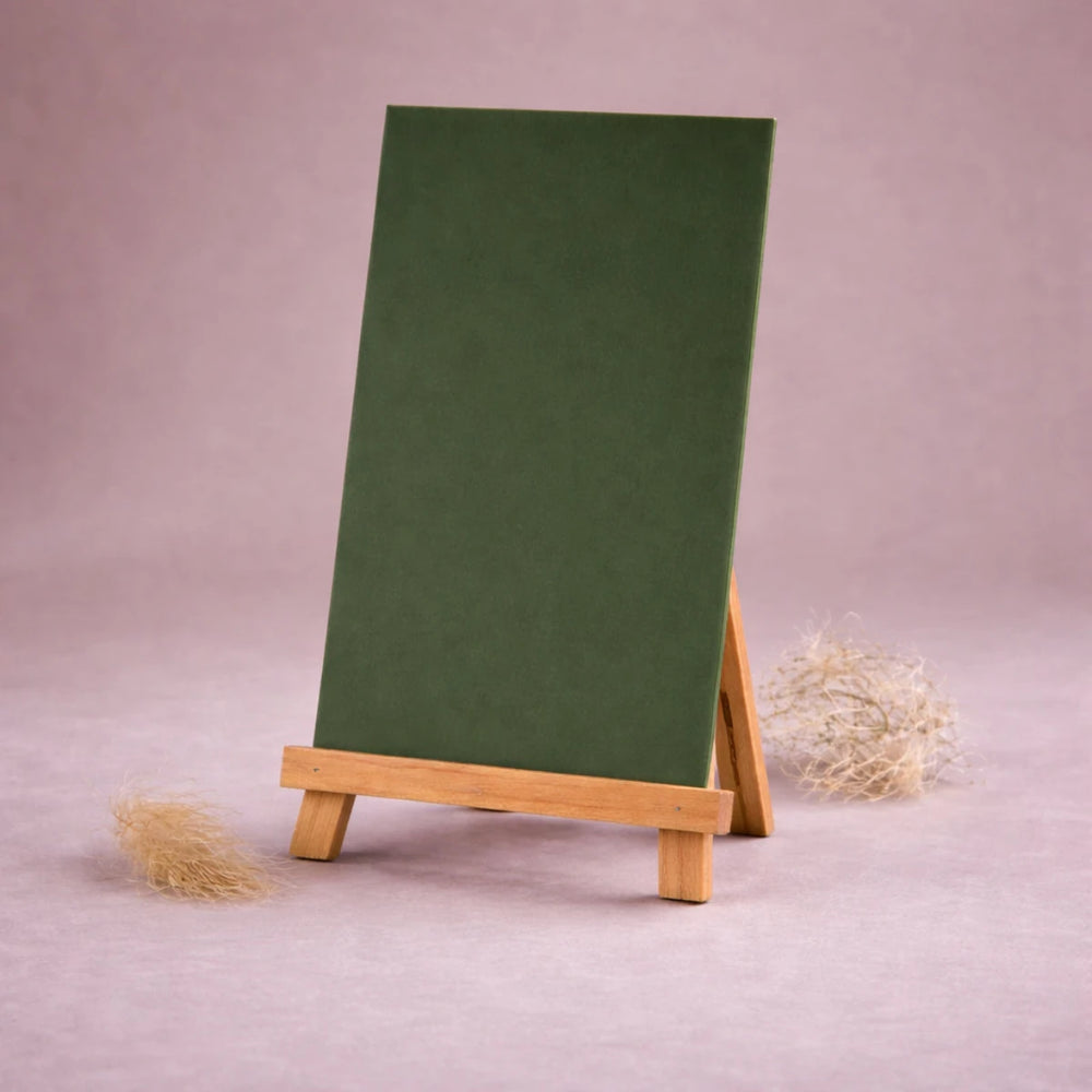 grasgruene wachsplatte zur kerzengestaltung auf kleiner holzstaffelei vor neutralem beigem hintergrund