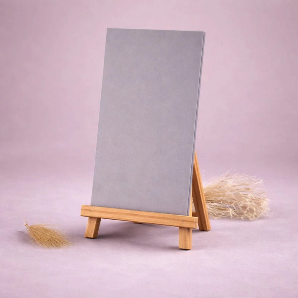 graue wachsplatte zur kerzengestaltung auf kleiner holzstaffelei vor hellem neutralem hintergrund