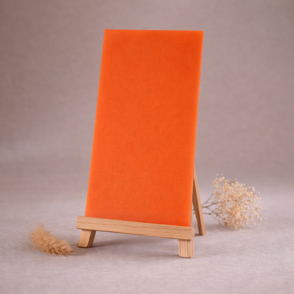 orange wachsplatte zur kerzengestaltung auf holzstaffelei vor beigem hintergrund
