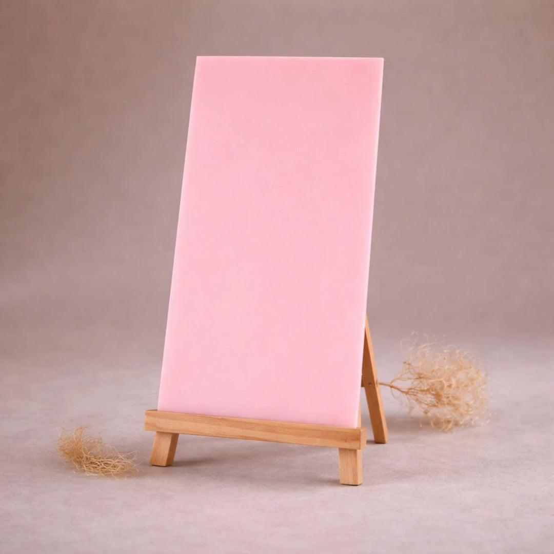 rosafarbene wachsplatte zur kerzengestaltung auf holzstaffelei vor beigem hintergrund
